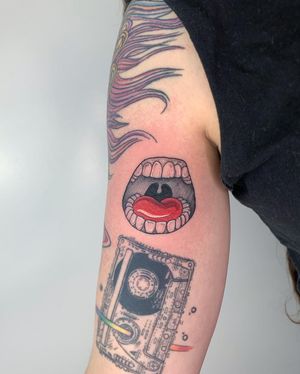 Get inked by Galen Bryce with an illustrative black and gray mouth and tongue design on your upper arm. Express your bold and edgy style with this unique tattoo.