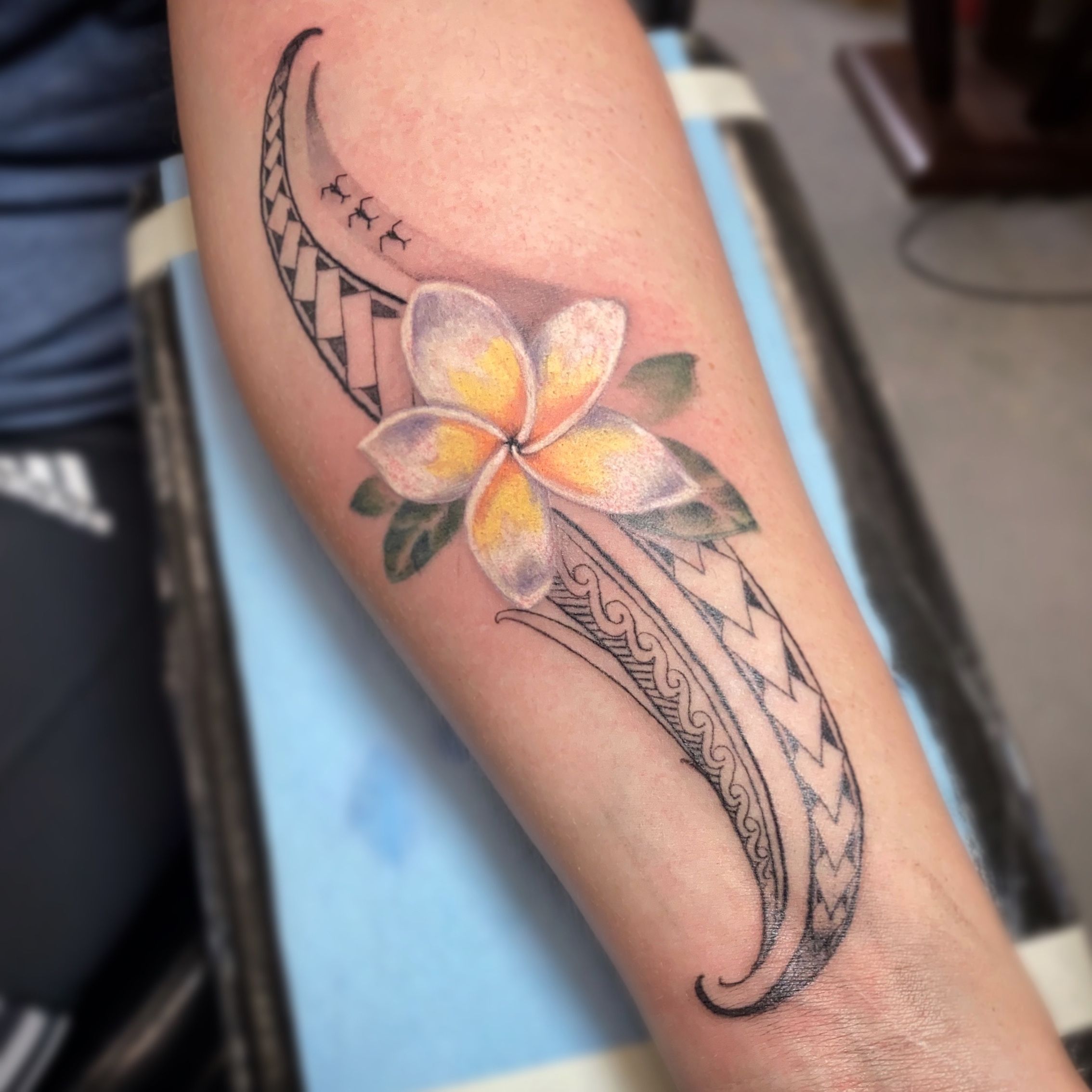 Hand poked frangipani tattoo on the inner forearm.