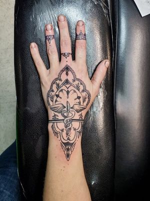 Simple fine line henna tattoo with nurse symbol.