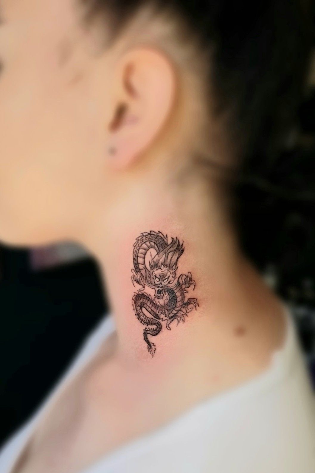 Tattoo of a red dragon done on the back of the neck