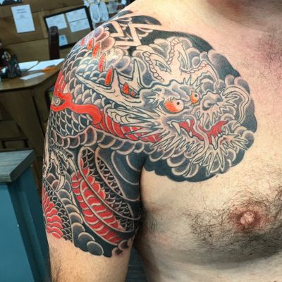 Embrace the power of a Japanese dragon with this stunning chest tattoo by renowned artist Ami James.