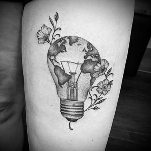 Beautiful blackwork upper arm tattoo featuring a bulb, lamp, and world map motif, expertly crafted by Jose Cordova.