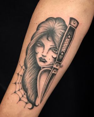 Stunning blackwork forearm tattoo featuring a beautifully detailed dagger and woman illustration by Felipe Reinoso.