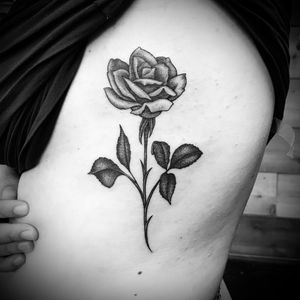 Elegant flower design by Jose Cordova, perfectly placed on the ribs for a bold and unique tattoo.
