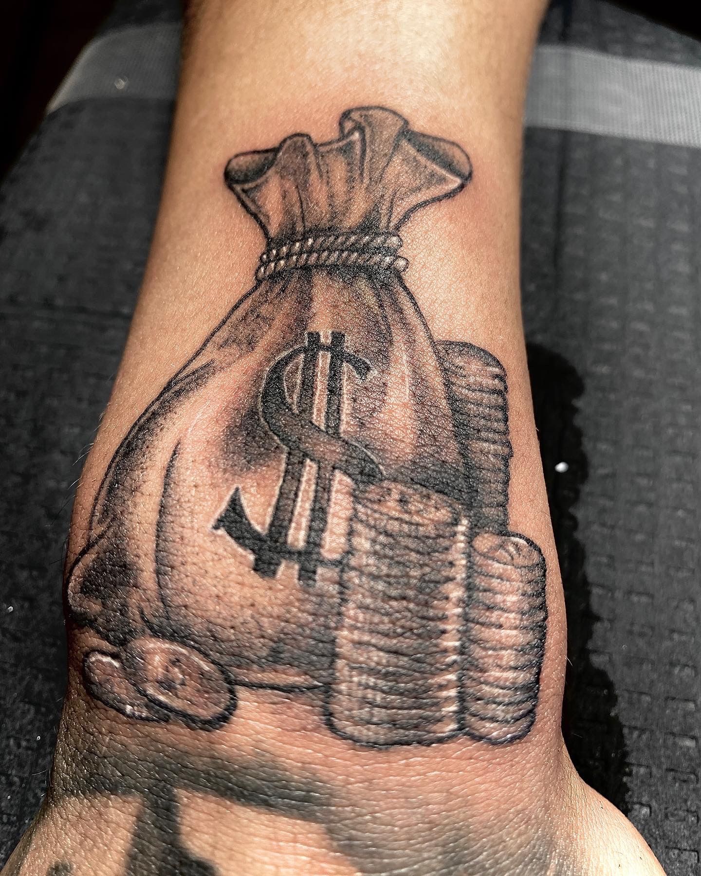 Money bag tattooed on the bicep.