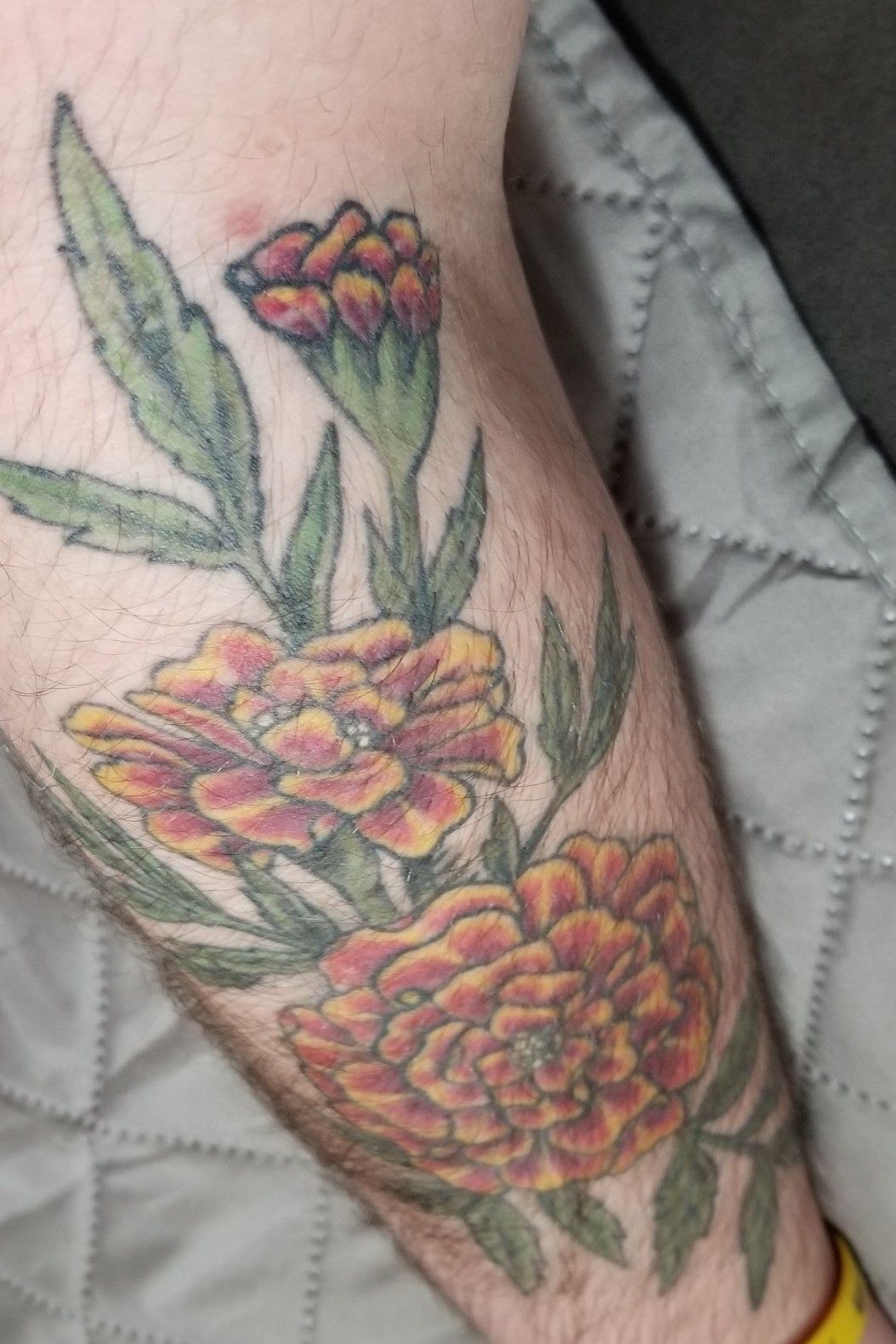 Fresh flowers, a marigold, spider mum, and carnation. Done by Brian Webb at  Eye Candy Tattoo Omaha, NE. : r/tattoos