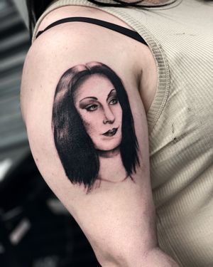 Eerie blackwork illustration by Miss Vampira, featuring a haunting woman motif on the upper arm.
