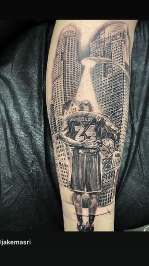 Illustrative black and gray tattoo of Kobe Bryant surrounded by buildings and basketball, by artist Jake Masri.