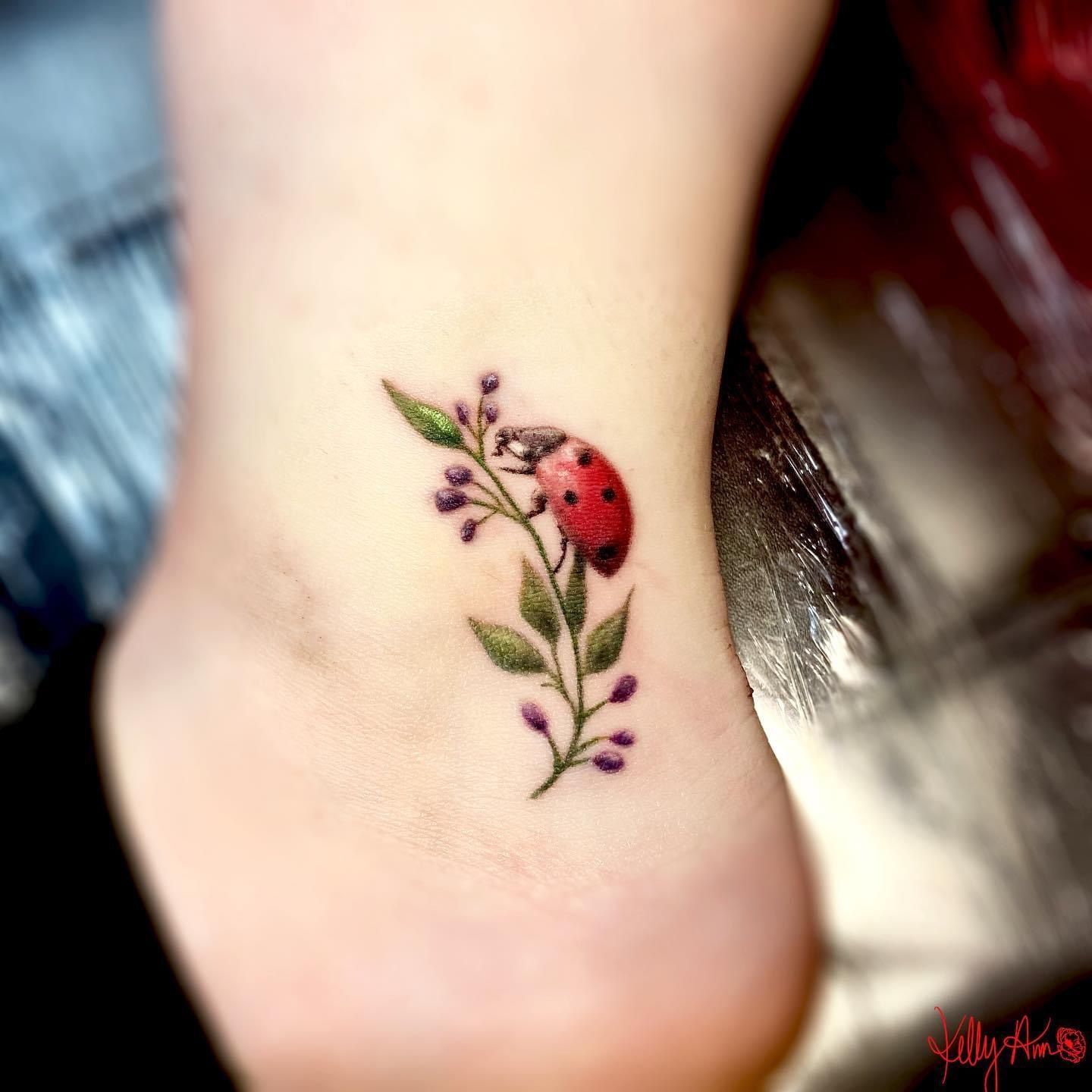 Small pink rose and ladybug tattoo on the inner