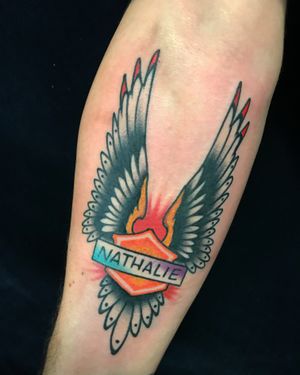 Get a classic lettering tattoo with wings and your name by Felipe Reinoso on your shin for a unique design.