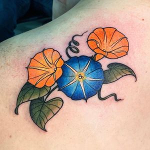 Beautiful and vibrant illustrative flower tattoo on upper back by artist Brigid Burke.