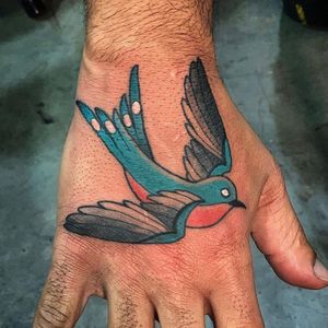 Get inked with a stunning illustrative bird design by Brigid Burke on your hand. Embrace traditional style with a touch of contemporary flair.