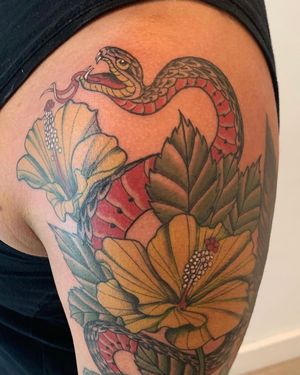 Capture the beauty of nature with this illustrative upper arm tattoo by artist Brigid Burke. The snake and flower motif symbolizes transformation and growth.