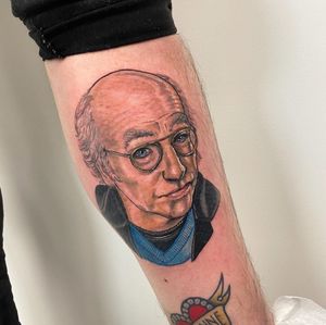 Vibrant new school tattoo on lower leg featuring a man wearing glasses, by artist Jethro Wood.