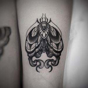 Elegant fusion of dotwork and neo-traditional styles on upper leg, featuring a mesmerizing moth design.