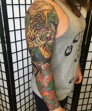 Experience the fierce elegance of a Japanese tiger and dragon motif expertly tattooed by renowned artist Kiko Lopes on your sleeve.