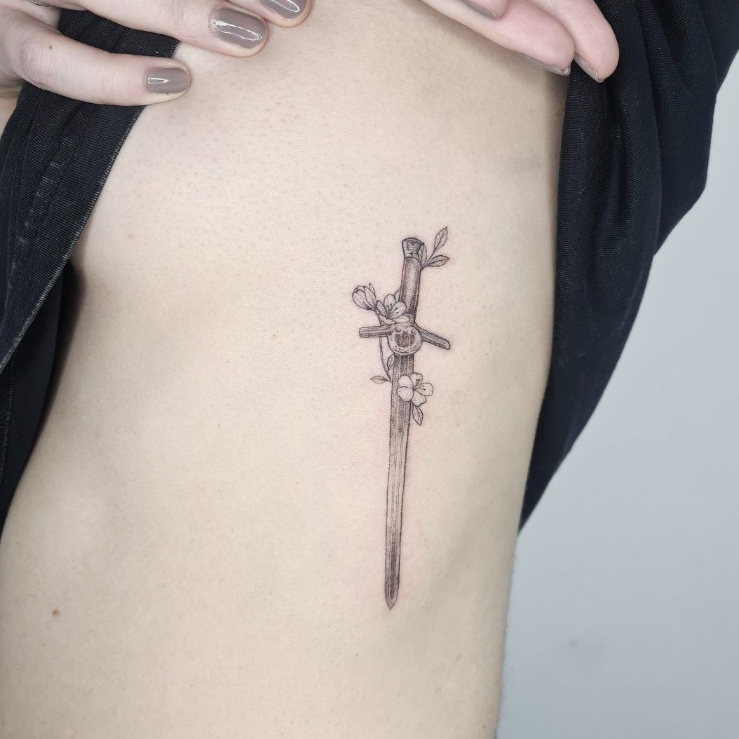Crane and sword tattoo done on the stomach fine line
