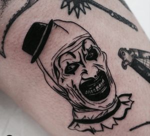 A spooky blackwork illustration of a clown hat on the arm by Miss Vampira.