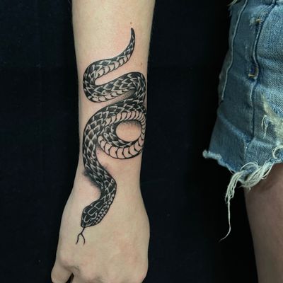Unique blackwork snake design by Felipe Reinoso, perfect for bold and striking forearm placement.