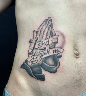 Beautiful black and gray tattoo of hands praying with a meaningful quote on the ribs by Felipe Reinoso.
