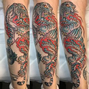 Get a fierce and traditional Japanese tiger tattoo on your lower leg in London, GB. This bold design represents strength and courage.