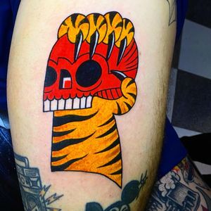 Get a fierce traditional tattoo of a tiger and skull on your lower leg in London, GB. Perfect blend of strength and danger.
