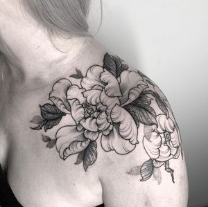 Get a beautiful floral peony tattoo on your shoulder in London. Feminine and elegant design.