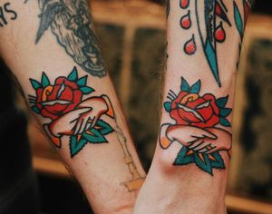 Get a beautiful traditional tattoo of a flower and hand on your forearm in London, GB. Expertly done by skilled artists.