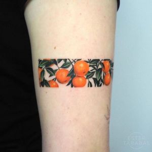 Get a vibrant illustrative orange tree tattoo on your upper arm in Los Angeles for a bold and striking look.