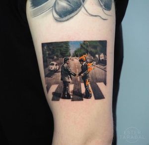 An illustrative tattoo featuring a man in a suit driving a car on fire down a road, perfect for upper arm placement in Los Angeles.