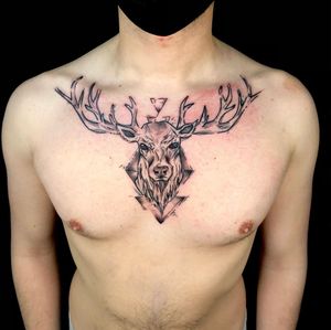 Elegant black and gray chest tattoo by Sandro Secchin featuring a majestic deer with intricate horns. Perfect for nature lovers.