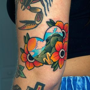 Max Rodriguez's stunning upper arm tattoo featuring a bold traditional design with elements of sun, mountain, flower, and heart.