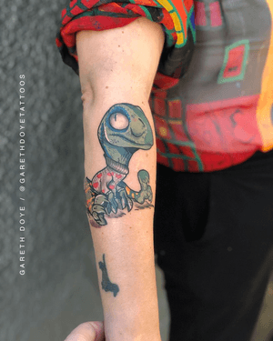 Vibrant new_school design on forearm by Gareth Doye, featuring a playful dino motif.
