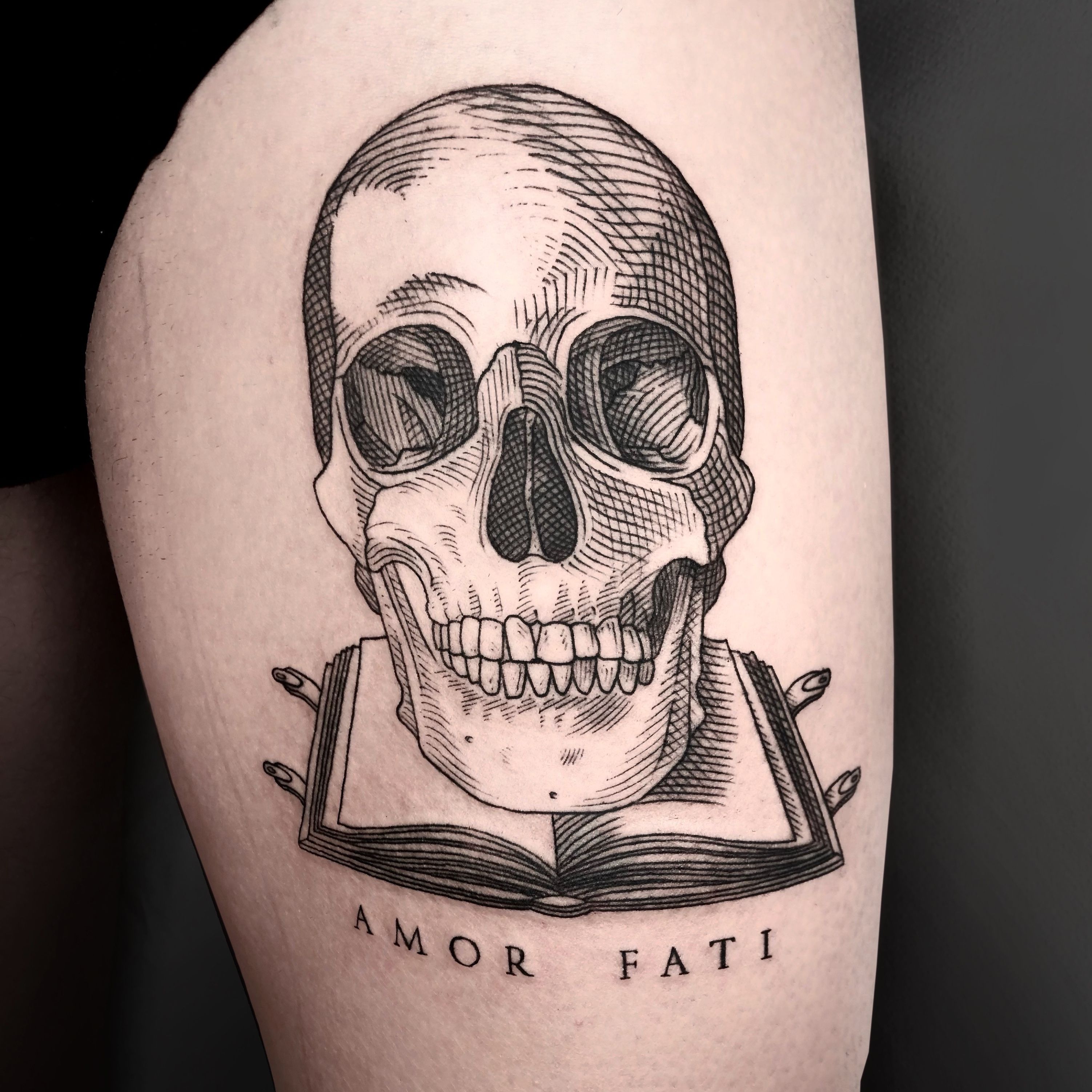 Amor Fati lettering tattoo on the inner forearm