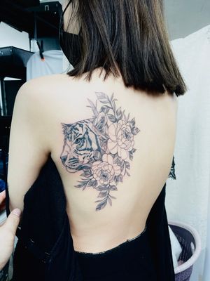 woman's back tiger pony tattoo