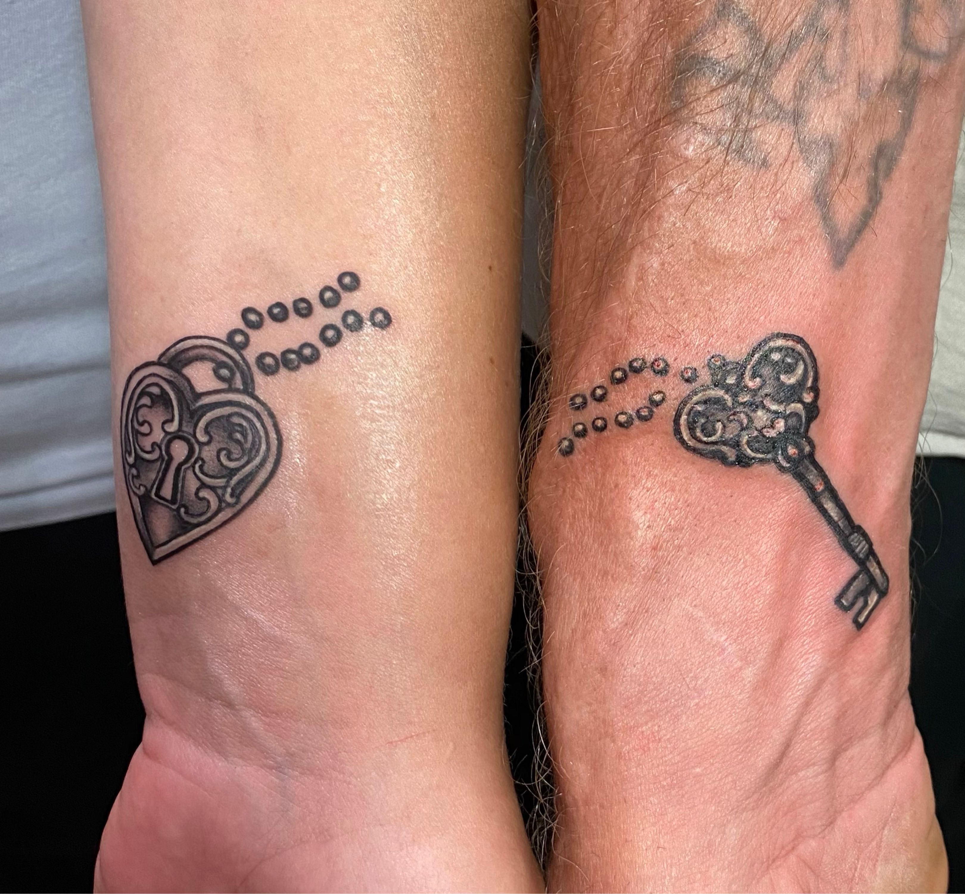 Lock and key matchig tattoo for couple done in fine