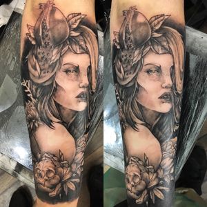 A striking blackwork and neo-traditional forearm tattoo featuring a skull and woman design by Frankie Brown.