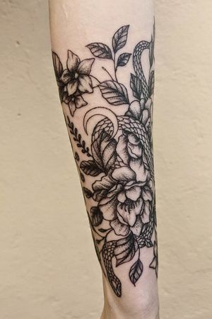 Flowers and snake on the girl’s forearm