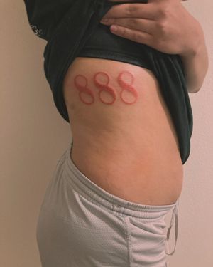 Orange angel numbers on the ribs. Done at Modern Day Martyrs off Southwest 6th Street in Amarillo, Texas.