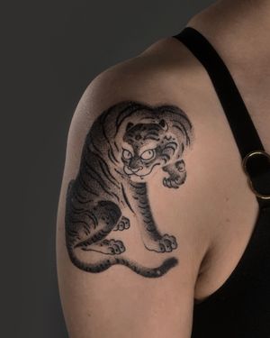 Impressive blackwork and dotwork design of a fierce tiger by FKM TATTOO, on shoulder. Perfect for bold statement seekers.