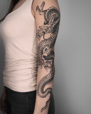 Experience the power of a fierce blackwork dragon in this stunning Japanese illustrative sleeve tattoo by FKM Tattoo.