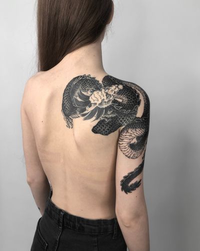 Impressive blackwork illustration of a dragon by FKM TATTOO, perfectly placed on the shoulder
