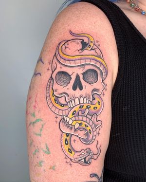 Vibrant and detailed upper arm tattoo of a snake intertwining with a skull, expertly done by Galen Bryce (aka Drip Skull).