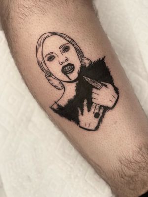 A bold blackwork tattoo on the upper arm featuring Lady Gaga, blood, and a ring. Illustrative style by Miss Vampira.