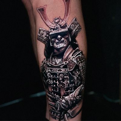 Get an intricate blackwork and realistic samurai helmet tattoo on your lower leg by artist Marcel Oliveira.