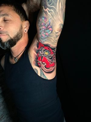 Experience the traditional artistry of a Japanese daruma tattoo on your arm by talented artist Marcel Oliveira.
