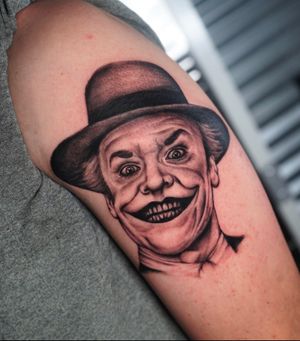 Detailed blackwork tattoo of Jack Nicholson's iconic Joker character wearing a hat, by skilled artist Miss Vampira