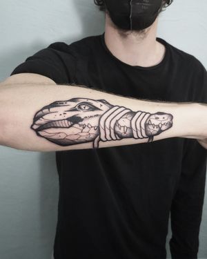 Blackwork tattoo of a crocodile with a tied mouth. Done by Christian Eisenhofer.
