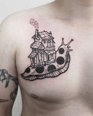 Schneckenhaus or Hausschnecke? A surreal, illustrative and funny tattoo of a snail carrying a real house by Christian Eisenhofer. 