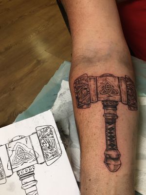 Experience the power of Thor with this stunning blackwork hammer tattoo by Frankie Brown. Perfect for lovers of Norse mythology!